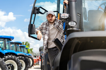 Portrait of man farm tractor driver posing on tractor. © Barillo_Images