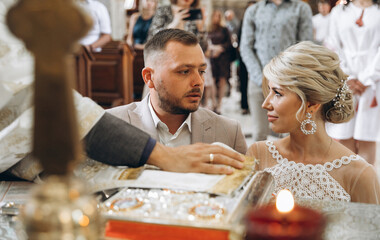 The groom takes an oath to the bride during the wedding ceremony in the church.