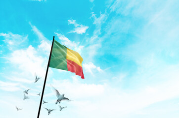 Benin flag waving with flying doves against sunset or sunrise. Benin flag for Republic Day and Independence Day.