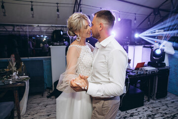 Bride and groom dancing the first wedding dance against the background evening restaurant