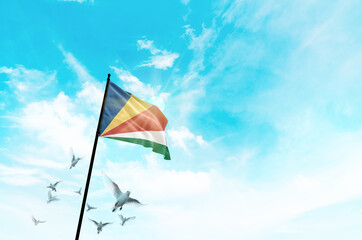 Seychelles flag waving with flying doves against sunset or sunrise. Seychelles flag for Republic Day and Independence Day.