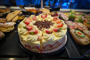 A freshly baked strawberry tart lies in the display of a bakery