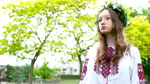 Ukrainian woman walking in fir forest, Carpathian mountains nature. Girl in traditional embroidery vyshyvanka dress, red wreath, ancient jewelry. Ukraine, freedom, ethnic national costume