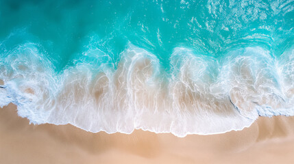 Fototapeta premium Aerial view of waves crashing onto a sandy beach with turquoise water.