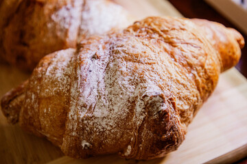 Crispy, fresh, homemade, oven-baked French croissant on a wooden plate; lots of croissants; coffee time; snack; cheat meal