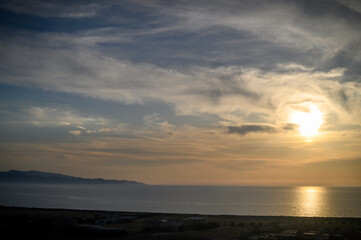 View of the sea, the waves and the sun in the shape of a star.