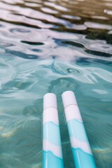 Two Blue and White Bottles Floating in a Pool