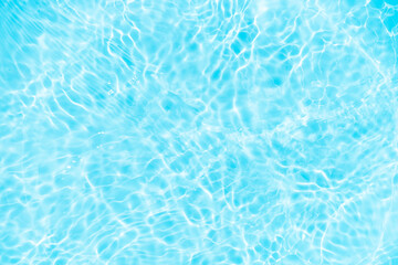Blue water with ripples on the surface. Defocus blurred transparent blue colored clear calm water surface texture with splashes and bubbles. Water waves with shining pattern texture background.