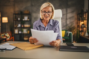 Mature woman work from home read good news in the letter post envelope