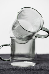 Zwei Glastassen in transparent grau vor einem weißen Hintergrund.
