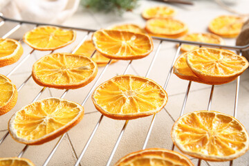 Stand with dried orange slices on white tile background