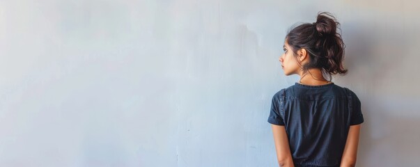 Obraz premium A woman with brown hair and a light skin tone is looking at the camera. She has a light pink lip color and a light brown eye color. Free copy space for text.
