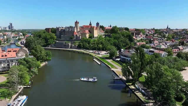 Aerial shot of a ferry crossing the Saale river in Bernburg. Bernburg Castle in the background. Windy but also sunny day. A town worth seeing in Saxony-Anhalt.