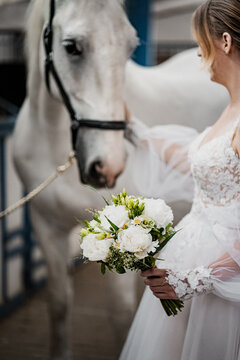 Bride holding a wedding flower. White horse on a wedding. Detail photos of wedding.