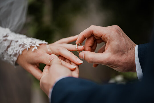 Newly wed couple giving a wedding ring. Cloe up detail of wedding ring and hands.