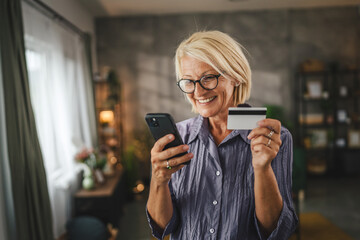Portrait of senior woman buy online on cellphone with credit card