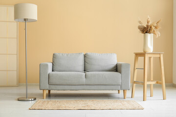 Stylish interior of living room with comfortable sofa and lamp