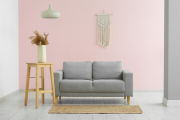 Comfortable sofa with carpet and pampas grass in living room