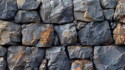 Detailed view of a rugged stone wall showcasing large weathered rocks. The texture and natural colors of the stones provide a rustic and sturdy appearance.