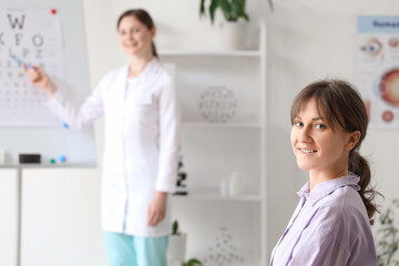 Young woman checking eyesight in clinic, closeup