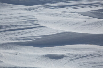 Fresh White Wintery Wind Blown Snow Drifts Background Image With Highlights and Shadows