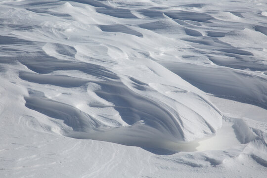Fresh White Wintery Wind Blown Snow Drifts Background Image With Highlights and Shadows