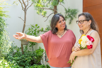 Fototapeta premium Woman welcoming her friend by giving her flowers