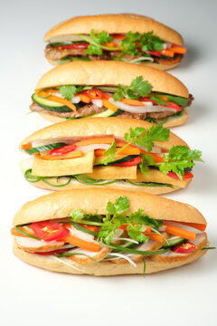 Four banh mi lined up on blank background
