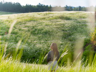 Asian woman who is lonely. In the grass, she is happy.