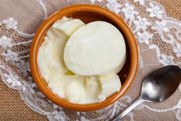 Clay pot contains fresh fermented milk curd with honey