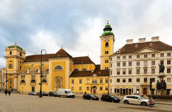 View of medieval Catholic church Schottenkirche and Schottenstift monastery on Freyung square in Vienna on cloudy winter day, Austria