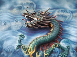 photo of big chinese dragon relief or statue on blue wall, as decoration in a biggest pagoda in...