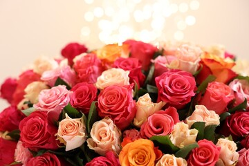 Beautiful bouquet of colorful roses on beige background, closeup