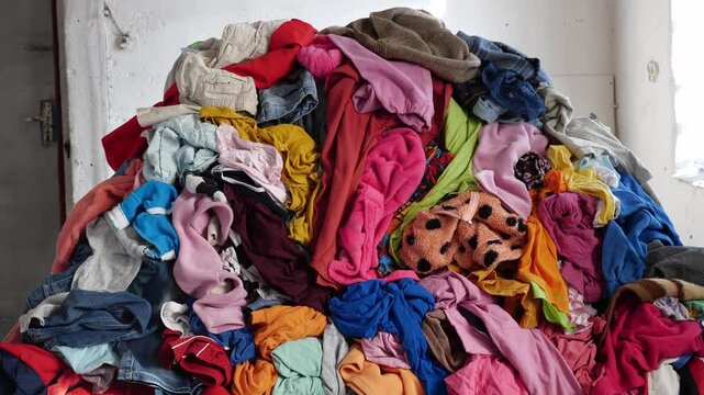 Used clothes. A big pile of old unnecessary clothes. Fast fashion, garbage and pollution