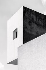 Minimalist black and white architecture photo of a modern building with striking geometric shapes and contrasting textures.