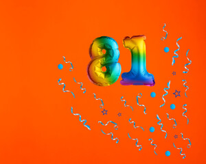 Multicolor balloon number 81 - Confetti explosion on orange background. Birthday card