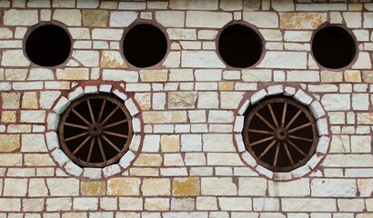 Rustic stone wall wagon wheels embedded decoration western feature design.