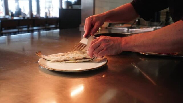 A fish being put on a plate and prepared