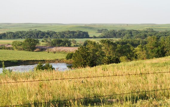 View from Telegraph Hill in the rural Kansas Flint Hills. It shows a farm pond for watering cattle. It also shows a small segment of BNSF Railways "Transcon" route. 