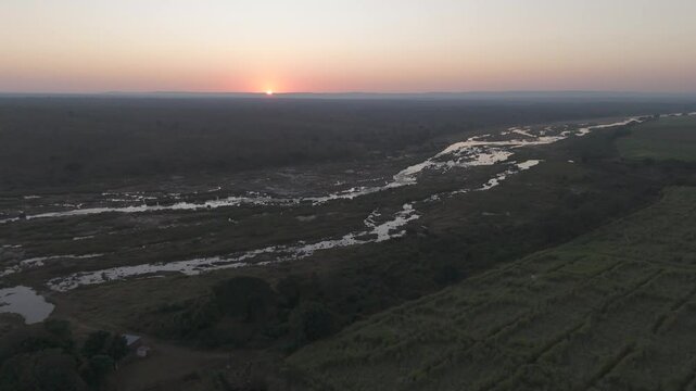 Drone flight over seasonal Crocodile River at sunrise bordering sugar cane farms, Crocodile River, Kruger National Park.