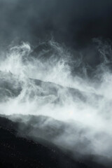 Fototapeta premium Fog forming abstract patterns as it moves through a landscape, symbolizing the ephemeral and transformative nature of creativity.