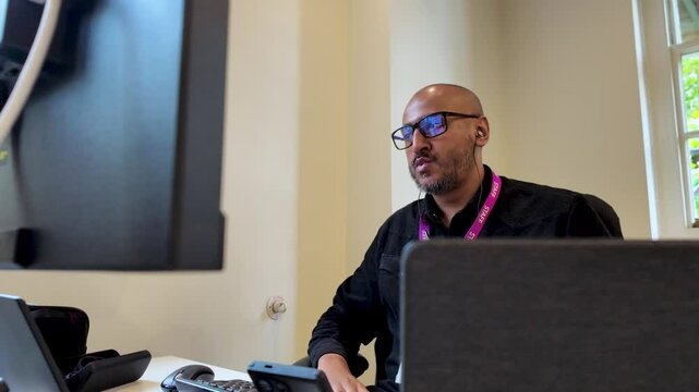 A Man Working In The Office With Earphones Listening To Music. Close-up Shot