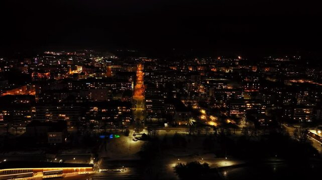 Drone overlooking the night lit Vaasa city skyline, winter evening in Finland