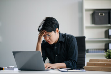 Fototapeta premium Businessman who is tired and overthinking from working with tablet and laptop