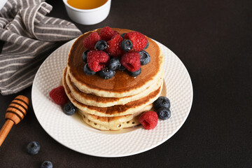 Homemade pancakes with berries on a dark background