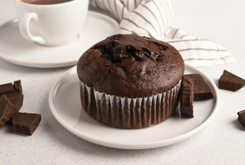 Chocolate muffin with a cup of coffee on a light background