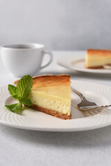 Slice of New York cheesecake on a concrete Light background