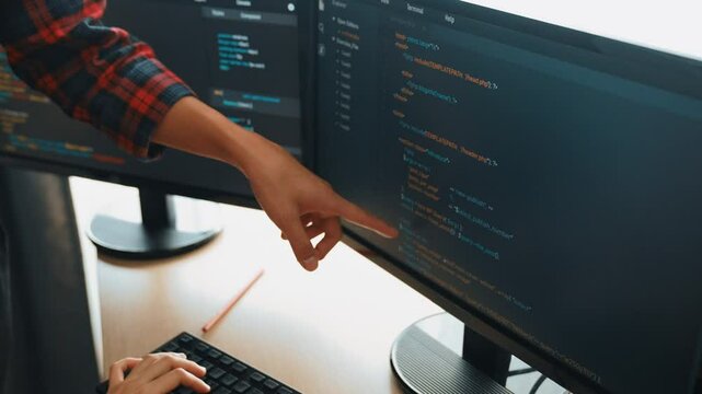 Slow motion back end or software developer manager supervising his team on new application program development on debugging and solving complex code algorithms on monitor. Burgeoning