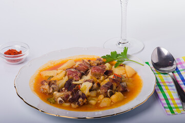 Dish with pork stewed with potatoes, onion, peppers and garlic.
