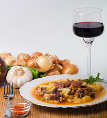 Dish with pork stewed with potatoes, onion, peppers and garlic.